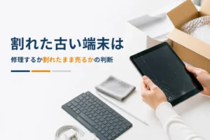 画面にひびが入ったタブレットを持ち上げる手元